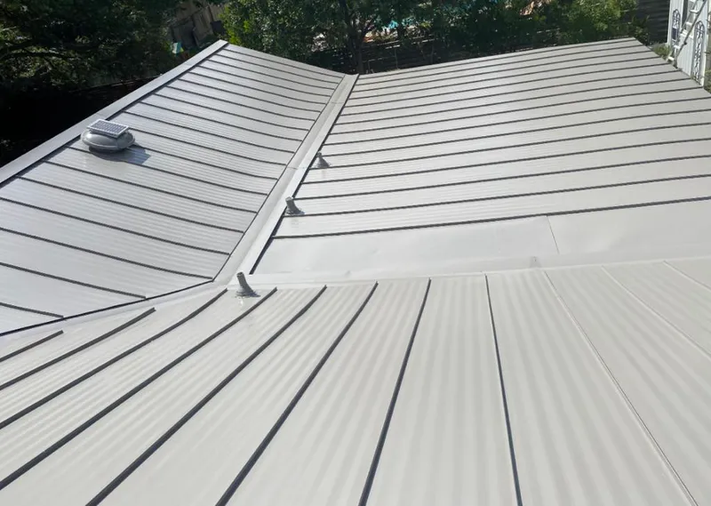Solar attic fan installed on a metal roof for Roof Ventilation in Maize